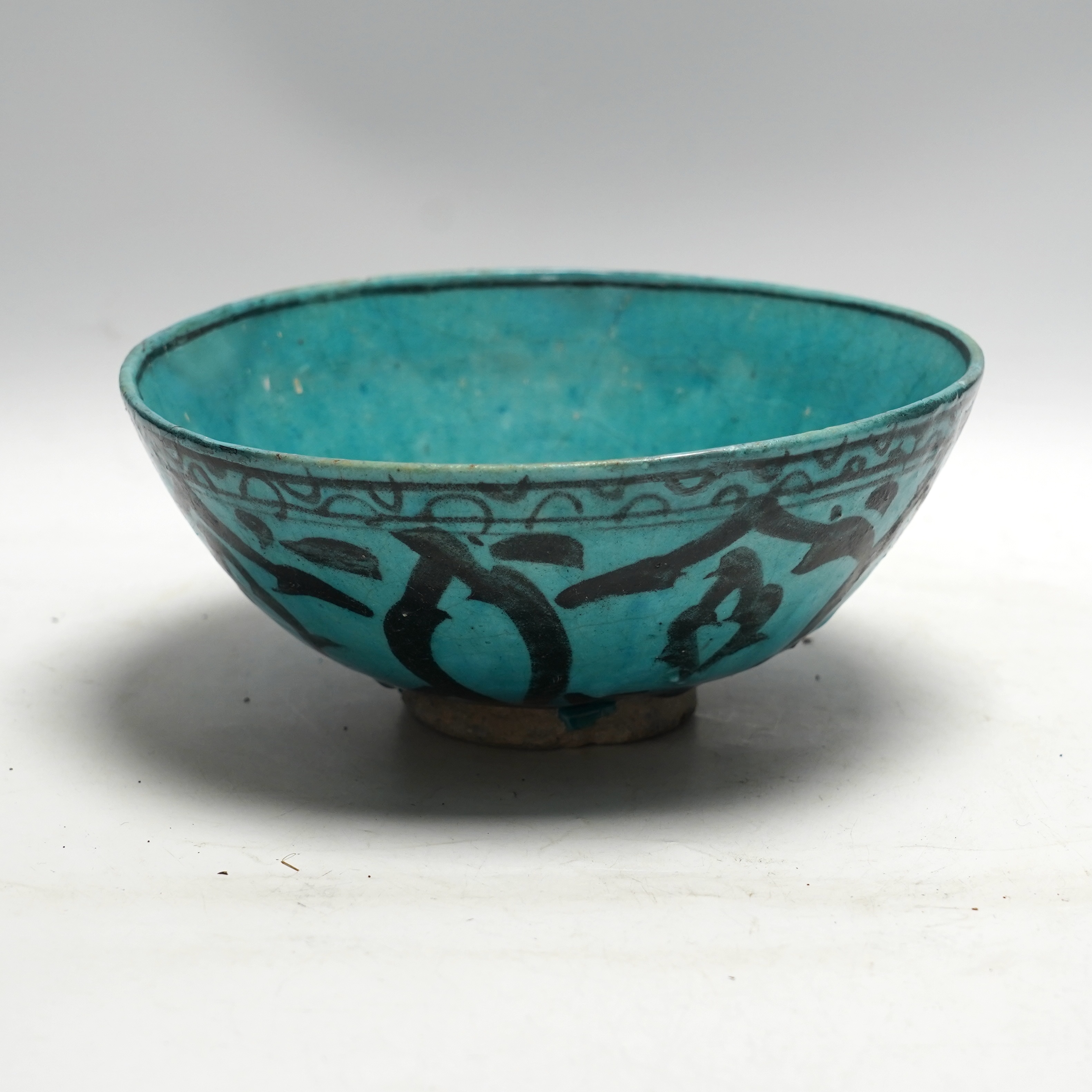 A Kashan turquoise glazed fritware bowl, Persia, 13th/14th century, 25cm diameter